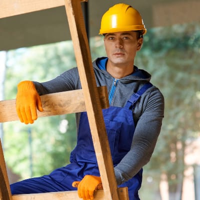 young-male-builder-in-overalls-and-hard-hat-lookin-69F7Z59.jpg